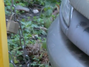 VIDEO: Řidič si připoutal automobil řetězem k zábradlí. Odtahu nezabránil