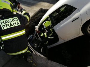 FOTO: Řidička v Praze 10 vjela do výkopu na silnici. Vyprostit ji museli hasiči