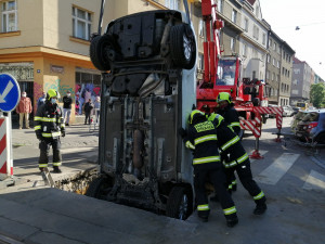 FOTO: Řidička v Praze 10 vjela do výkopu na silnici. Vyprostit ji museli hasiči