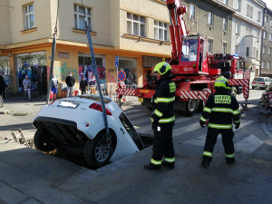 FOTO: Řidička v Praze 10 vjela do výkopu na silnici. Vyprostit ji museli hasiči