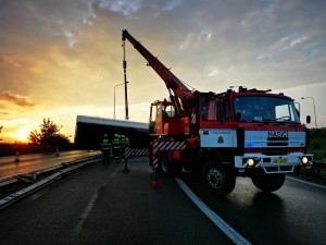 Na sjezdu z Pražského okruhu se převrátil kamion, návěs musel zvedat jeřáb.