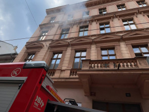 Požár bytu v Praze přerušil dopravu. Hasiči zachránili čtyři lidi a jednoho psa