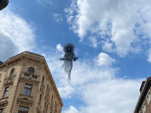Nad ulicí v centru Prahy se vznáší nová socha. Lidé jsou nadšení i zděšení