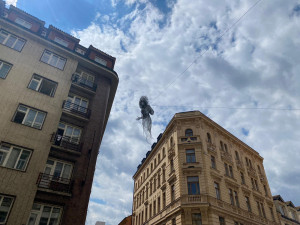Nad ulicí v centru Prahy se vznáší nová socha. Lidé jsou nadšení i zděšení