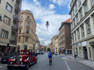 Nad ulicí v centru Prahy se vznáší nová socha. Lidé jsou nadšení i zděšení