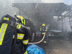 VIDEO: Hasiči zasahovali u požáru autoservisu v Praze. Hořela auta i tlakové lahve