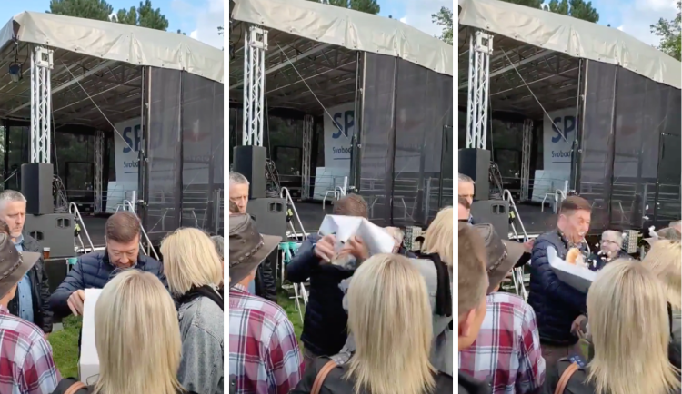 VIDEO: Žena chtěla na mítinku v Praze hodit Okamurovi do obličeje štrúdl. Zadržela ji policie