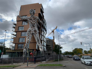 Obří ocelová socha ženy, která podpírá bytový dům, bude otáčet hlavou