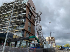 Obří ocelová socha ženy, která podpírá bytový dům, bude otáčet hlavou