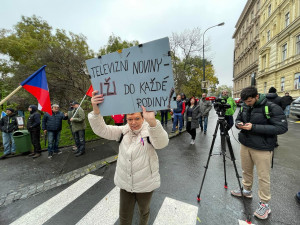 Lidé nesou transparenty a vlajky