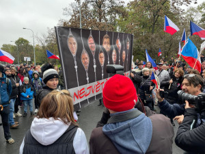 Lidé nesou transparenty a vlajky