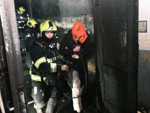 V Trojické ulici hořelo v chodbě domu. Hasiči zachraňovali deset lidí