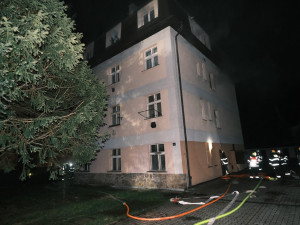 Noční požár domu v Praze. Jeden popálený člověk a jedenáct evakuovaných