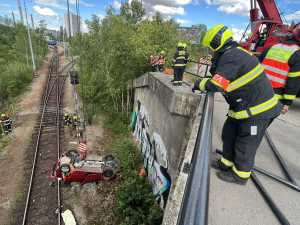 Sedmdesátiletá řidička spadla s autem z deseti metrů na koleje
