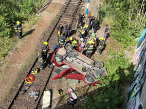 Sedmdesátiletá řidička spadla s autem z deseti metrů na koleje