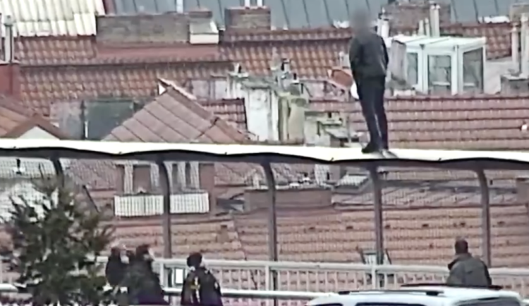 Muž stál na plotě a chtěl skočit.