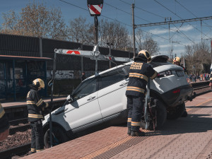 VIDEO: Řidička zaparkovala, auto ale nezabrzdila. Vůz sjel na koleje a blokoval vlaky