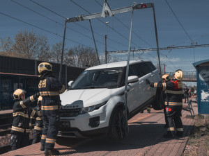 VIDEO: Řidička zaparkovala, auto ale nezabrzdila. Vůz sjel na koleje a blokoval vlaky