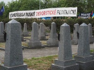 FOTOGALERIE: Vztyčené prostředníčky, karafiáty a ruské vlajky. Podívejte se, jak vypadala návštěva Nočních vlků na Olšanských hřbitovech