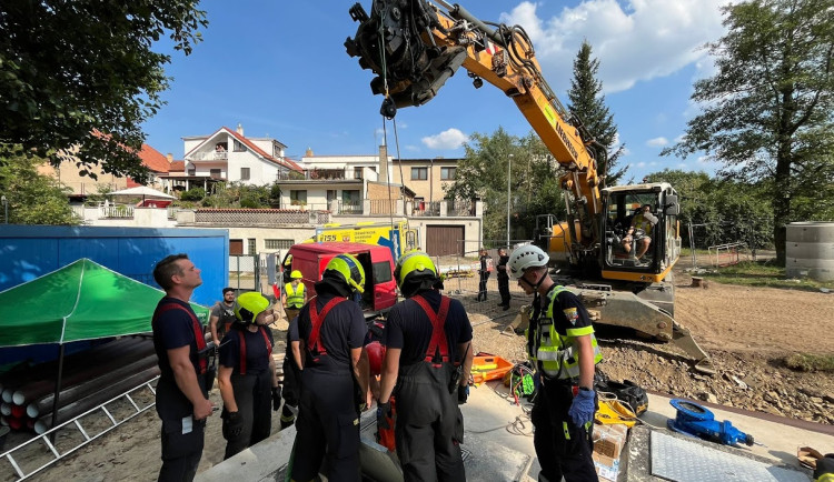 Hasiči vyprostili muže, který spadl do jímky. Využili k tomu bagr ze stavby