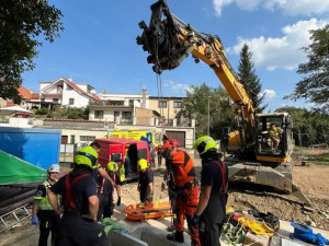 Hasiči vyprostili muže, který spadl do jímky. Využili k tomu bagr ze stavby