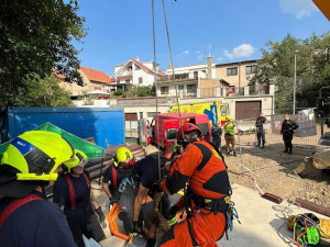 Hasiči vyprostili muže, který spadl do jímky. Využili k tomu bagr ze stavby