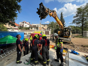 Hasiči vyprostili muže, který spadl do jímky. Využili k tomu bagr ze stavby