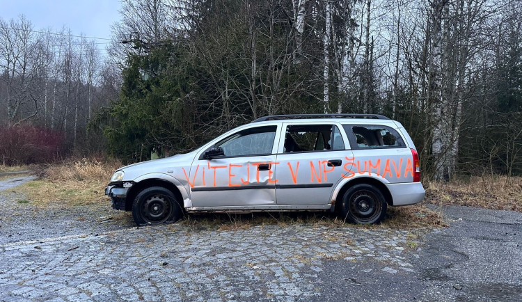 Už rok hyzdí NP Šumava odstavený autovrak. Neznámý vtipálek ho opatřil nápisem, jenž vítá v národním parku