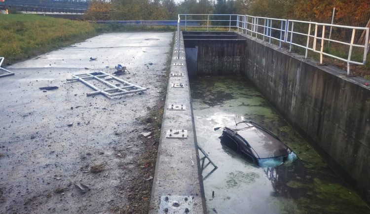 Auto vyletělo z dálnice, prorazilo zábradlí a utopilo se v nádrži na dešťovku