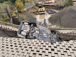 Na stavbě v Praze se utrhl svah, auto městské policie skončilo na střeše