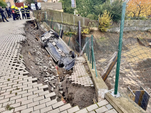 Na stavbě v Praze se utrhl svah, auto městské policie skončilo na střeše