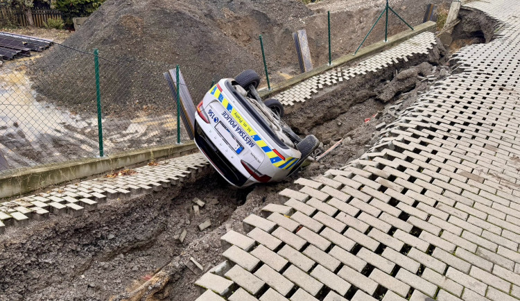 Na stavbě v Praze se utrhl svah, auto městské policie skončilo na střeše