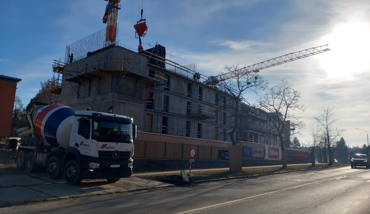 FOTO: Dělníci staví poslední patro vysokoškolských kolejí, soudní spory pokračují