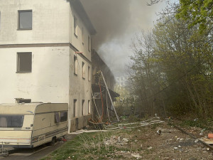 Na Žižkově hoří ubytovna, hasiči zachraňují lidi pomocí žebříků