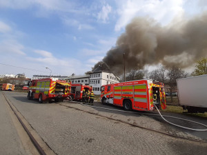 Na Žižkově hoří ubytovna, hasiči zachraňují lidi pomocí žebříků