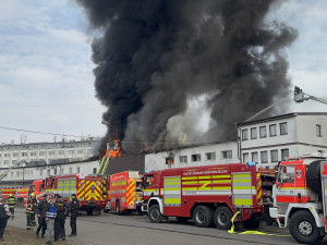 Na Žižkově hoří ubytovna, hasiči zachraňují lidi pomocí žebříků