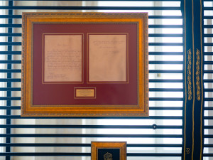 Černý pás vyšívaný zlatou nití s monograme prezidenta Petra Pavla předaný při oficiální návštěvě Černé hory a Bosny a Hercegoviny.