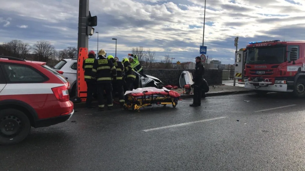 Vážná nehoda na Trojském mostě. Hasiči museli vyprostit dvě osoby z vraku auta.