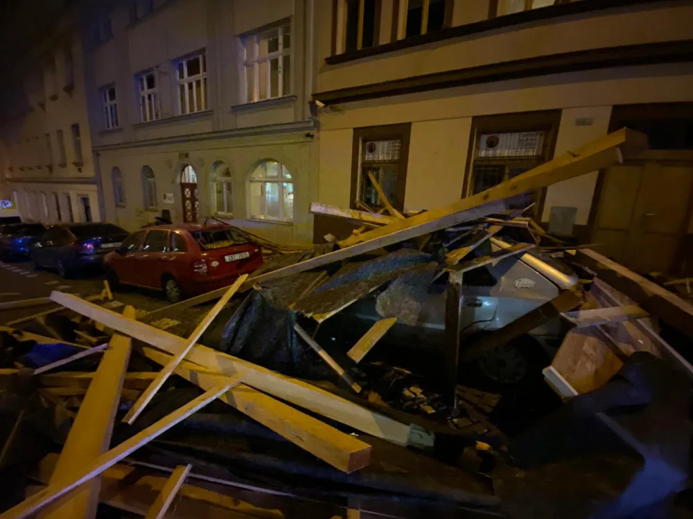 FOTO, VIDEO: Trámy z rozestavěné střechy na Žižkově zasypaly několik zaparkovaných aut