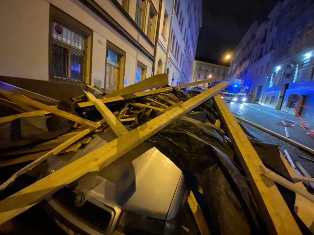 FOTO, VIDEO: Trámy z rozestavěné střechy na Žižkově zasypaly několik zaparkovaných aut