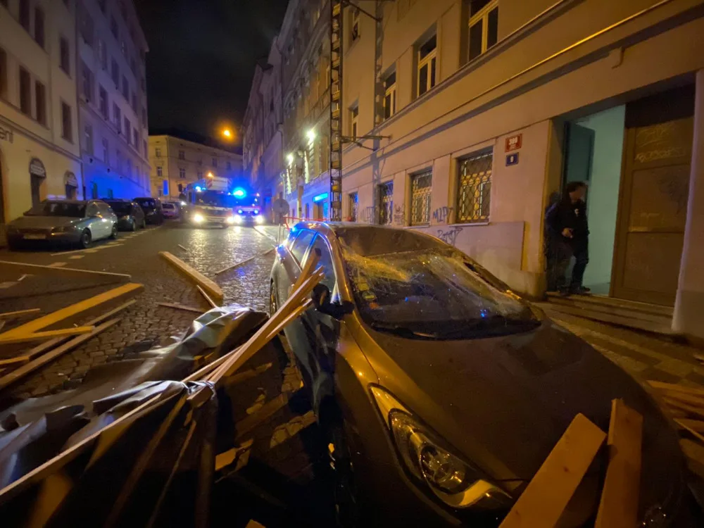 FOTO, VIDEO: Trámy z rozestavěné střechy na Žižkově zasypaly několik zaparkovaných aut
