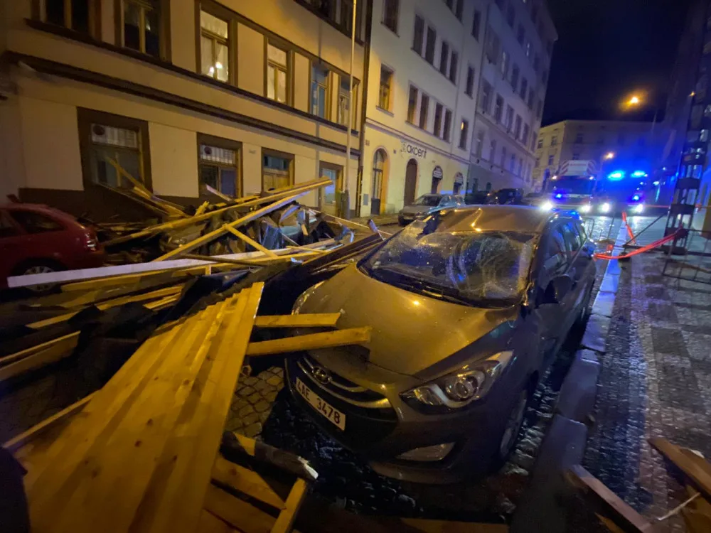 FOTO, VIDEO: Trámy z rozestavěné střechy na Žižkově zasypaly několik zaparkovaných aut