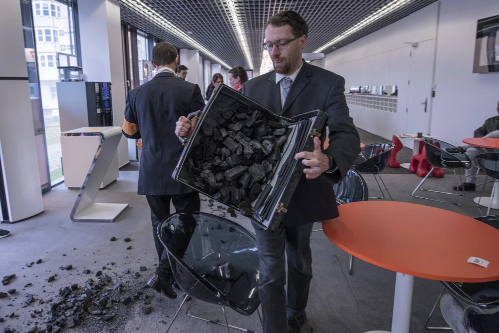 FOTO: Do sídla ČEZu vnikli aktivisté, pomalovali okna a v zákaznickém centru rozházeli uhlí
