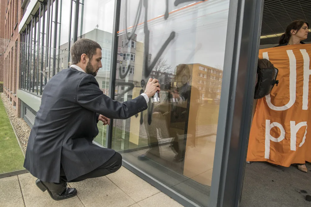 FOTO: Do sídla ČEZu vnikli aktivisté, pomalovali okna a v zákaznickém centru rozházeli uhlí
