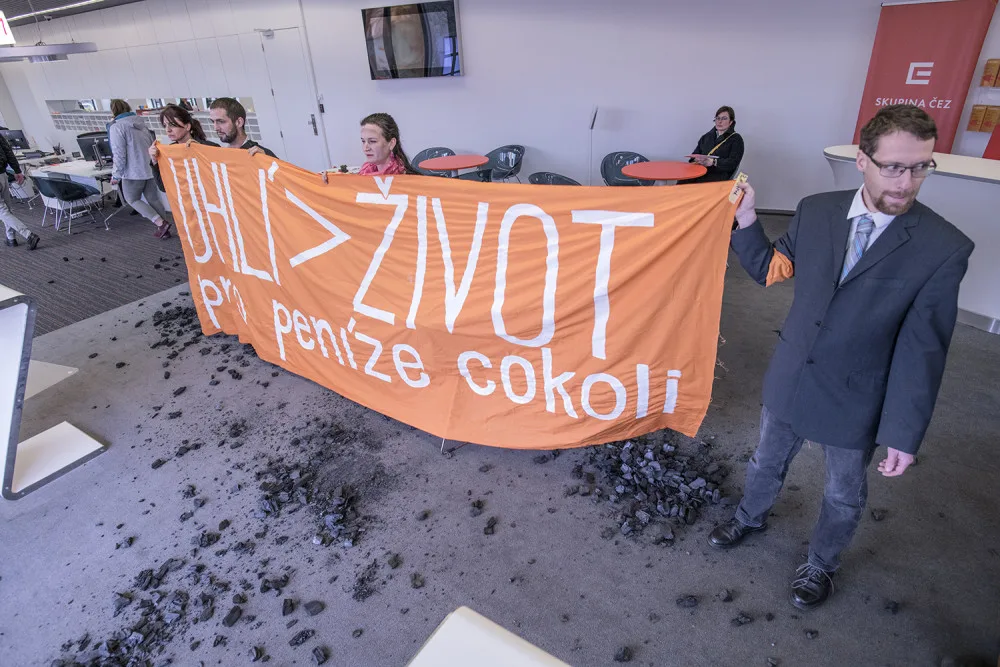 FOTO: Do sídla ČEZu vnikli aktivisté, pomalovali okna a v zákaznickém centru rozházeli uhlí