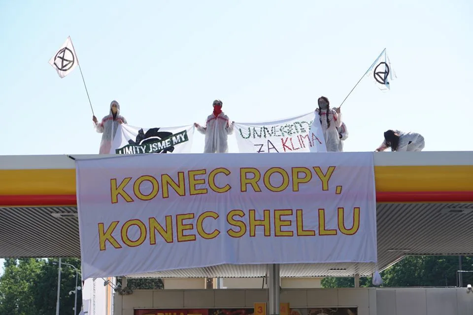 Aktivisté obsadili střechy tří pražských čerpacích stanic. Hasiči jim pomáhali dolů