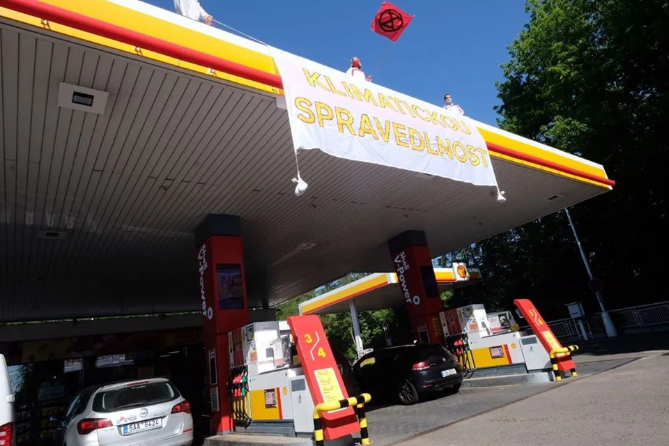 Aktivisté obsadili střechy tří pražských čerpacích stanic. Hasiči jim pomáhali dolů