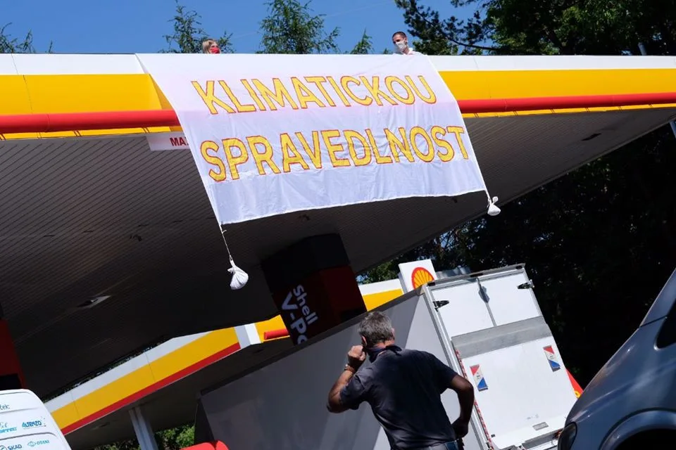 Aktivisté obsadili střechy tří pražských čerpacích stanic. Hasiči jim pomáhali dolů