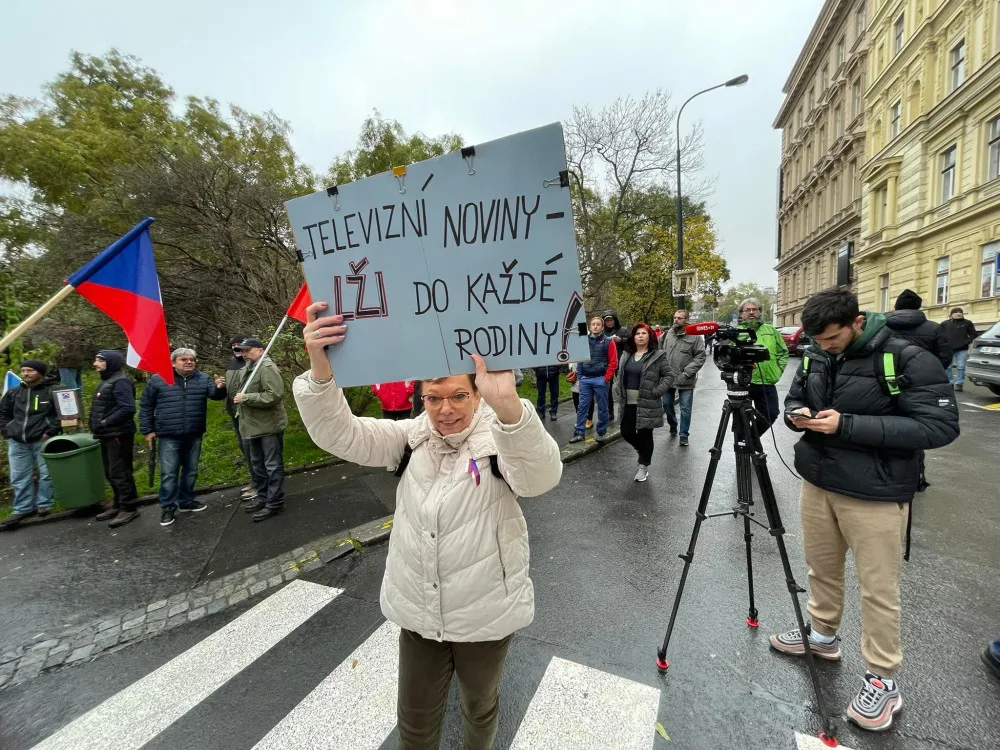 Lidé nesou transparenty a vlajky