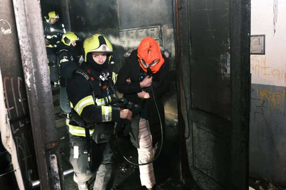 V Trojické hořelo v chodbě domu. Hasiči zachraňovali deset lidí